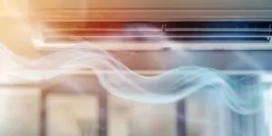 Dirty air filter on wooden surface causing HVAC smells and poor air quality