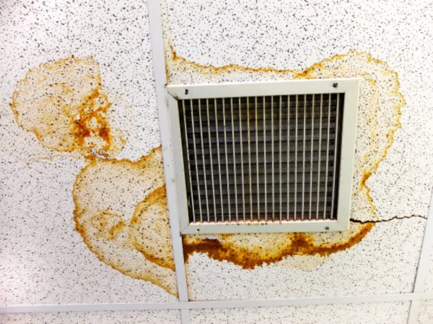 Air duct inspections revealing water damage stains on ceiling tiles around an air vent