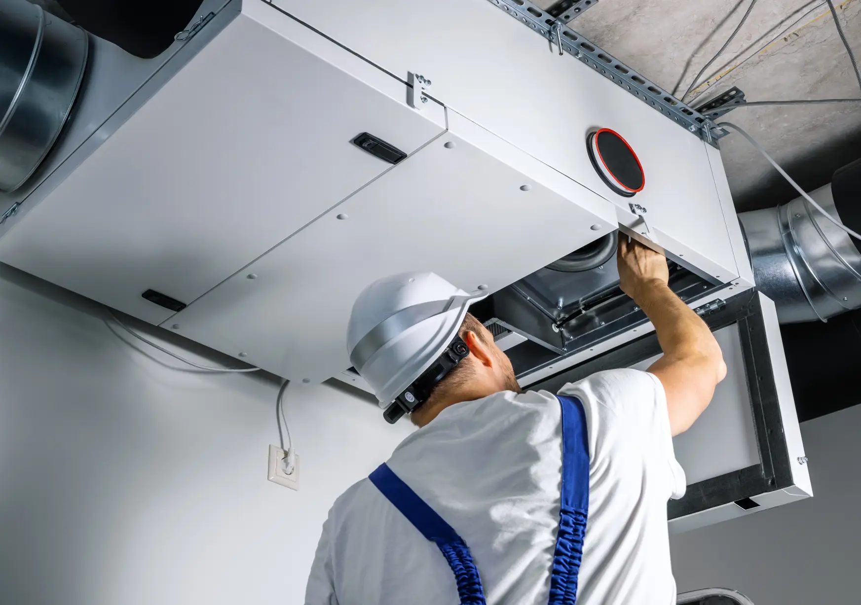 HVAC engineer installing a heat recovery ventilation (HRV) system during a heating maintenance service in Arizona for a new home